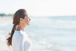 a woman stares at the ocean and considers attending dual diagnosis treatment programs in arizona