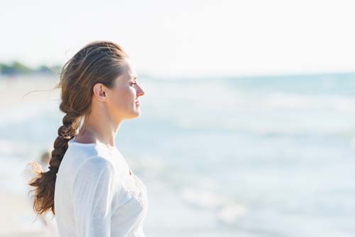 a woman stares at the ocean as she considers attending viewpoint dual recovery center