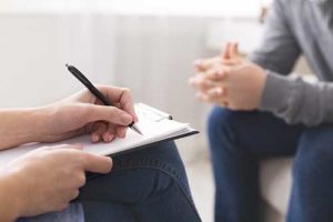 a therapist at a ptsd treatment center takes notes on a patients ptsd treatment program in arizona