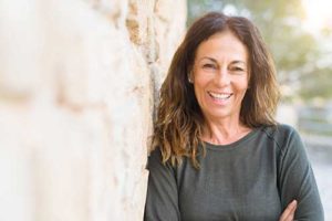 a woman leans against the wall as she thinks about addiction treatment therapies in arizona