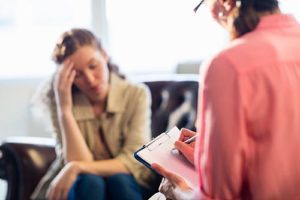 a woman talks to her therapist at a cognitive behavioral therapy program in arizona