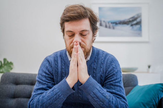 a man folds his hands and thinks about anxiety treatment during covid 19