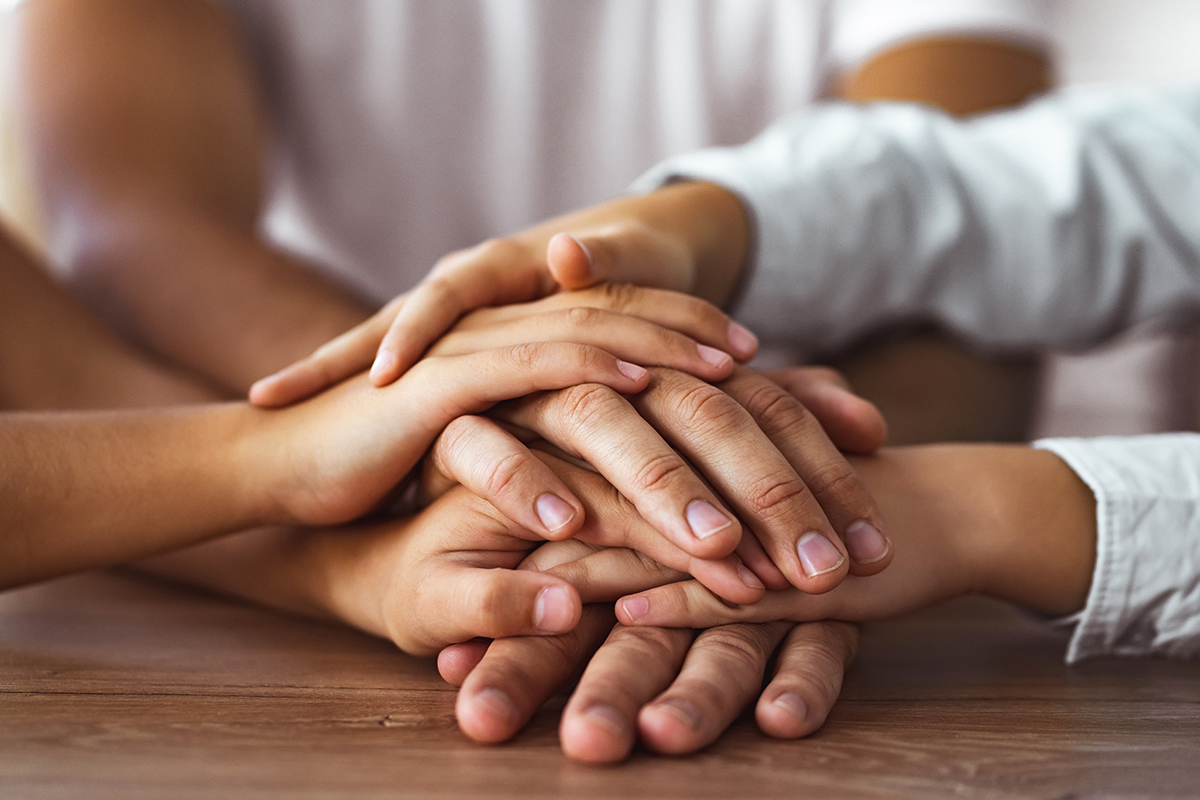 a group of people join hands as they discuss the connection between addiction and your family