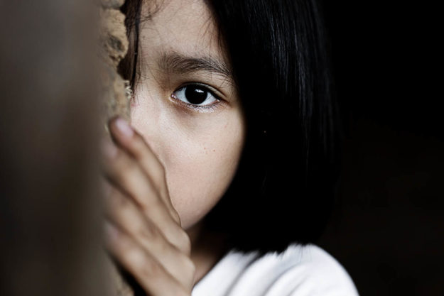 a young girl hiding while not knowing about Childhood Trauma and Addiction