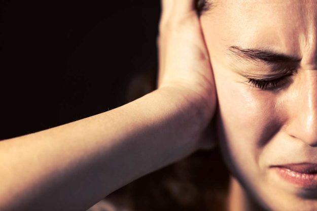 a woman feeling stressed after experiencing signs of bipolar disorder