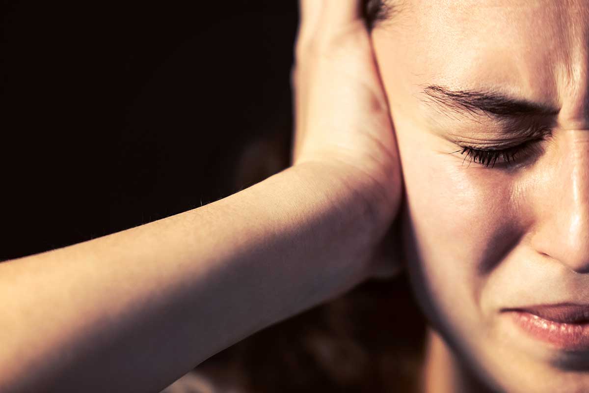 a woman feeling stressed after experiencing signs of bipolar disorder
